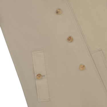 Close-up of Sealup beige raincoat front pocket and button detail, highlighting premium craftsmanship and minimalist design.