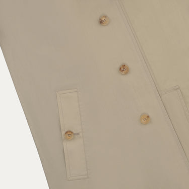 Close-up of Sealup beige raincoat front pocket and button detail, highlighting premium craftsmanship and minimalist design.