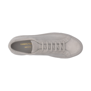 Top view of Common Projects Achilles Tonal sneaker in light grey suede, showcasing sleek silhouette and gold branding inside.