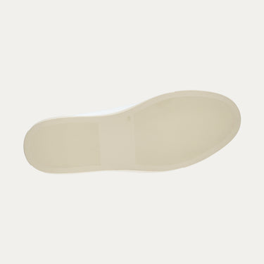 Outsole view of Common Projects Retro Low white sneaker showing beige rubber sole with textured grip, from SS25 collection.