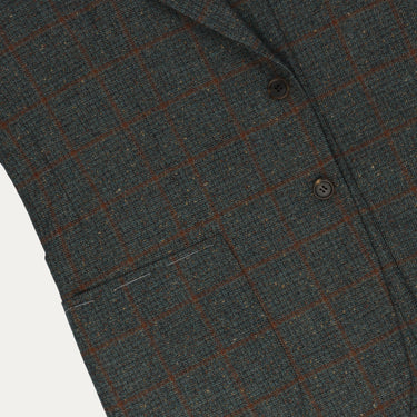 Close-up of Orazio Luciano wool checked jacket highlighting front pocket and detailed brown check pattern on soft green fabric.