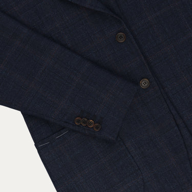 Close-up of sleeve and buttons on Orazio Luciano Prince of Wales checked jacket in dark blue and brown. Features refined tailoring and functional buttonholes.