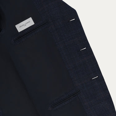 Interior view of Orazio Luciano checked jacket showing label and inner pockets. Luxurious lining and structured design for premium menswear appeal.