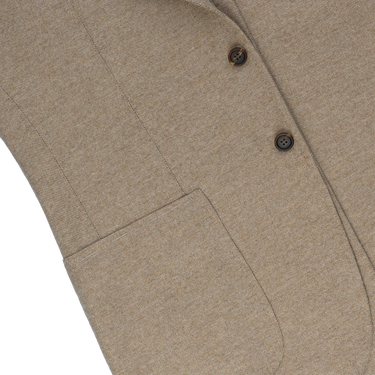 Close-up of front patch pocket and textured wool fabric on Orazio Luciano beige jacket, highlighting refined tailoring details.
