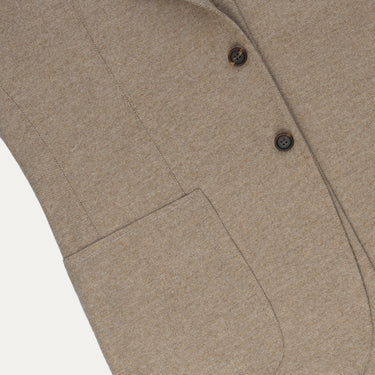 Close-up of front patch pocket and textured wool fabric on Orazio Luciano beige jacket, highlighting refined tailoring details.