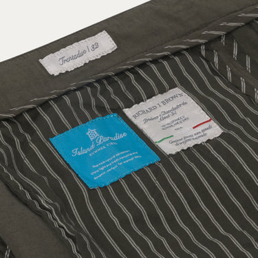 Interior label details of Richard J. Brown Caprera Trousers in Dark Green, highlighting Italian craftsmanship and Island Paradise SS25 collection.