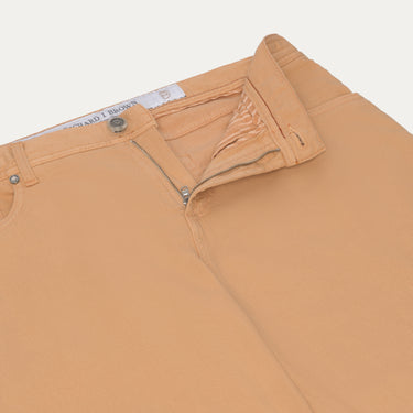 Close-up of Richard J. Brown peach jeans showing zip fly and waistband details, highlighting craftsmanship and premium finish.