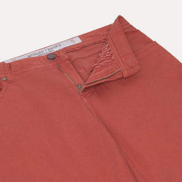 Close-up of Richard J. Brown red coral jeans showing zipper fly and waistband details, combining comfort and style.