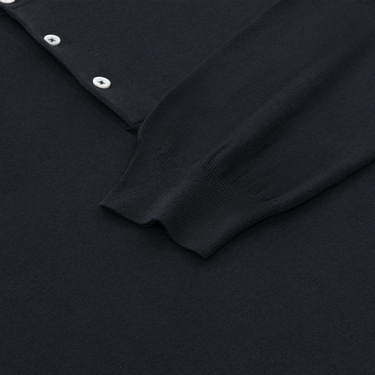 Detail of Cruciani long sleeve polo shirt cuff and hem in dark blue cotton-silk blend, emphasizing luxury knitwear quality and finish.