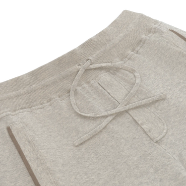 Close-up of Cruciani light grey knitted cotton trousers showing drawstring waistband and front pocket detail, part of SARTALE's new SS25 line.