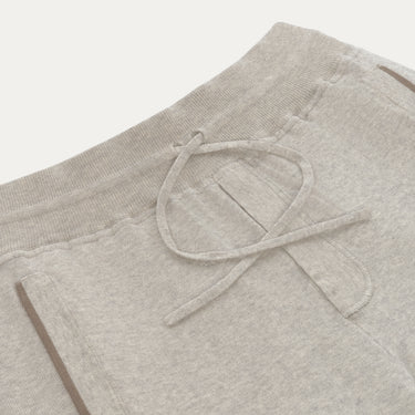 Close-up of Cruciani light grey knitted cotton trousers showing drawstring waistband and front pocket detail, part of SARTALE's new SS25 line.
