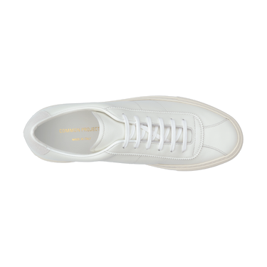 Top view of Common Projects 'Tennis Classic' sneaker in white leather, showcasing clean laces and gold branding inside the shoe.
