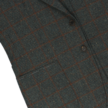 Close-up of Orazio Luciano wool checked jacket highlighting front pocket and detailed brown check pattern on soft green fabric.