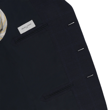 Interior view of Orazio Luciano suit jacket showing label and inner pockets. High-quality tailoring meets luxury design in this navy wool suit.