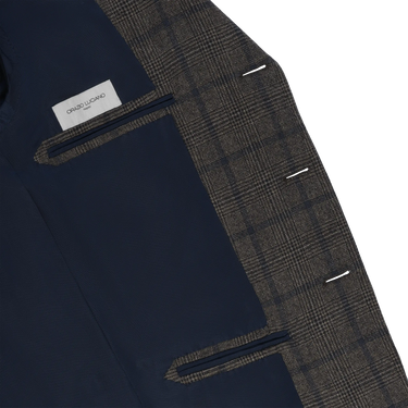 Interior view of Orazio Luciano checked wool jacket with navy lining and label, showcasing luxury tailoring and premium finish.