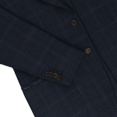 Close-up of sleeve and buttons on Orazio Luciano Prince of Wales checked jacket in dark blue and brown. Features refined tailoring and functional buttonholes.
