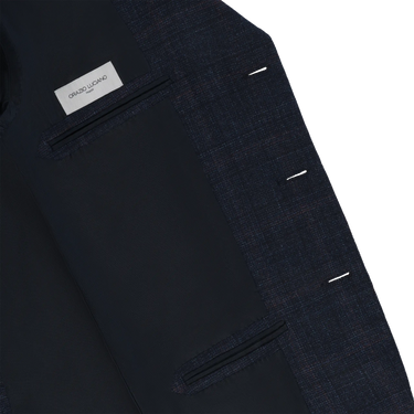Interior view of Orazio Luciano checked jacket showing label and inner pockets. Luxurious lining and structured design for premium menswear appeal.