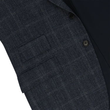 Close-up of Orazio Luciano suit jacket pocket detail in dark blue Prince of Wales wool, highlighting craftsmanship and premium fabric texture.