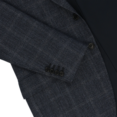Detailed view of Orazio Luciano suit sleeve with four-button cuff and Prince of Wales check pattern in dark blue wool, tailored for luxury appeal.