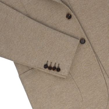 Detail of sleeve buttons and pocket stitching on Orazio Luciano beige wool jacket, emphasizing artisanal construction and style.