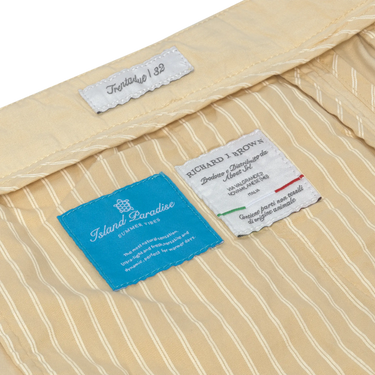 Interior label details of Caprera Cream Trousers by Richard J. Brown, highlighting Island Paradise lining and premium Italian craftsmanship.