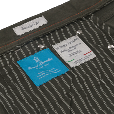 Interior label details of Richard J. Brown Regular-Fit 5 Pocket Jeans in Dark Green, showing brand tags and striped lining.