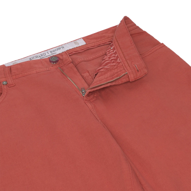 Close-up of Richard J. Brown red coral jeans showing zipper fly and waistband details, combining comfort and style.